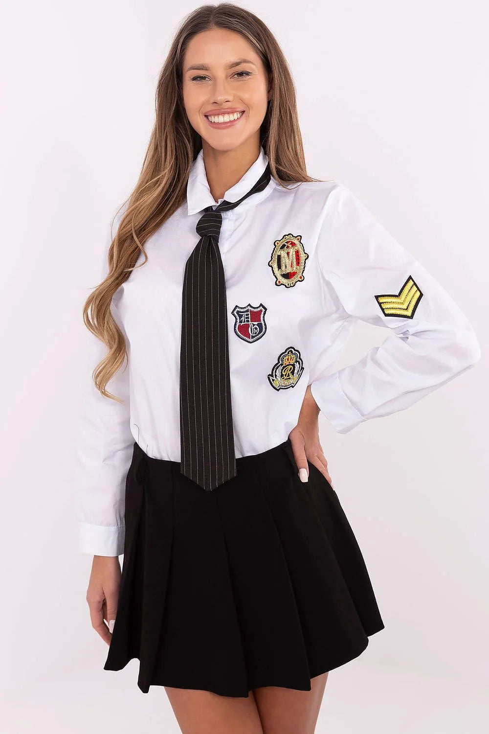 Ensemble féminin academia style chemise blanche manches longues jupe noire plissée écussons brodés cravate rayée accessoires mode décontractée élégance
